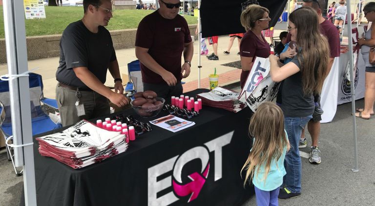 EQT employees talking to people at a event booth