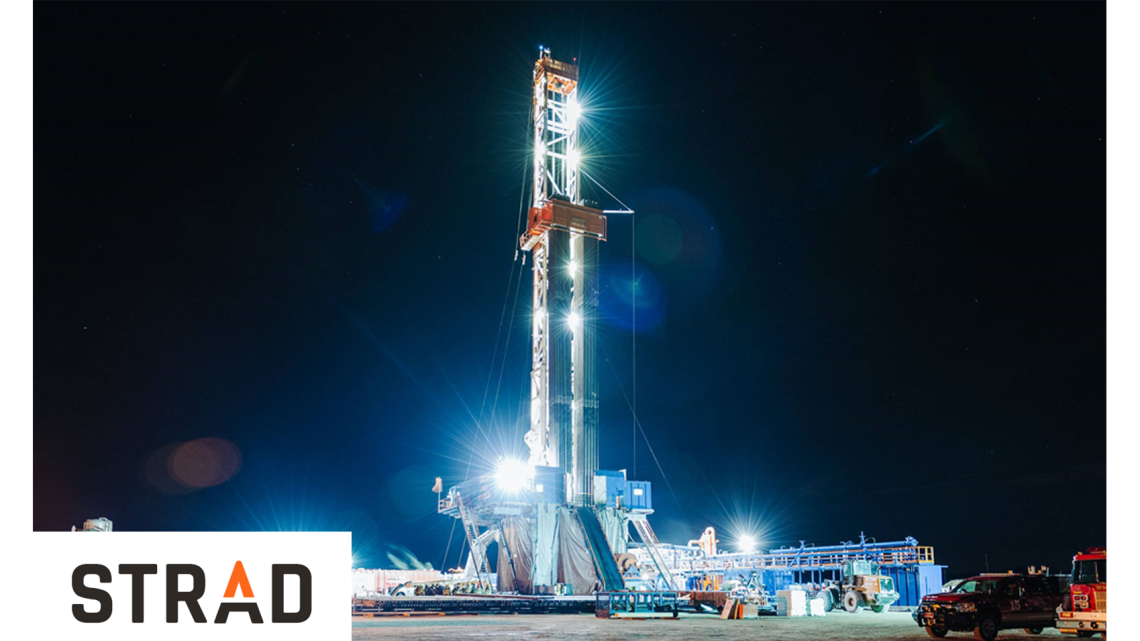 natural gas rig lit up at night with Strad's logo